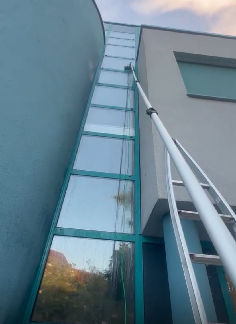 Verglaste Fassade und Glasdach eines Gebäudes von unten fotografiert